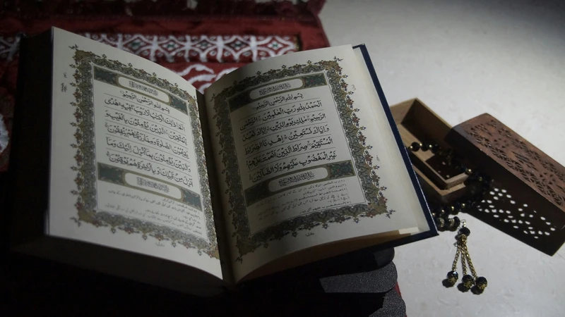 Open Quran with prayer beads on decorative wooden stand